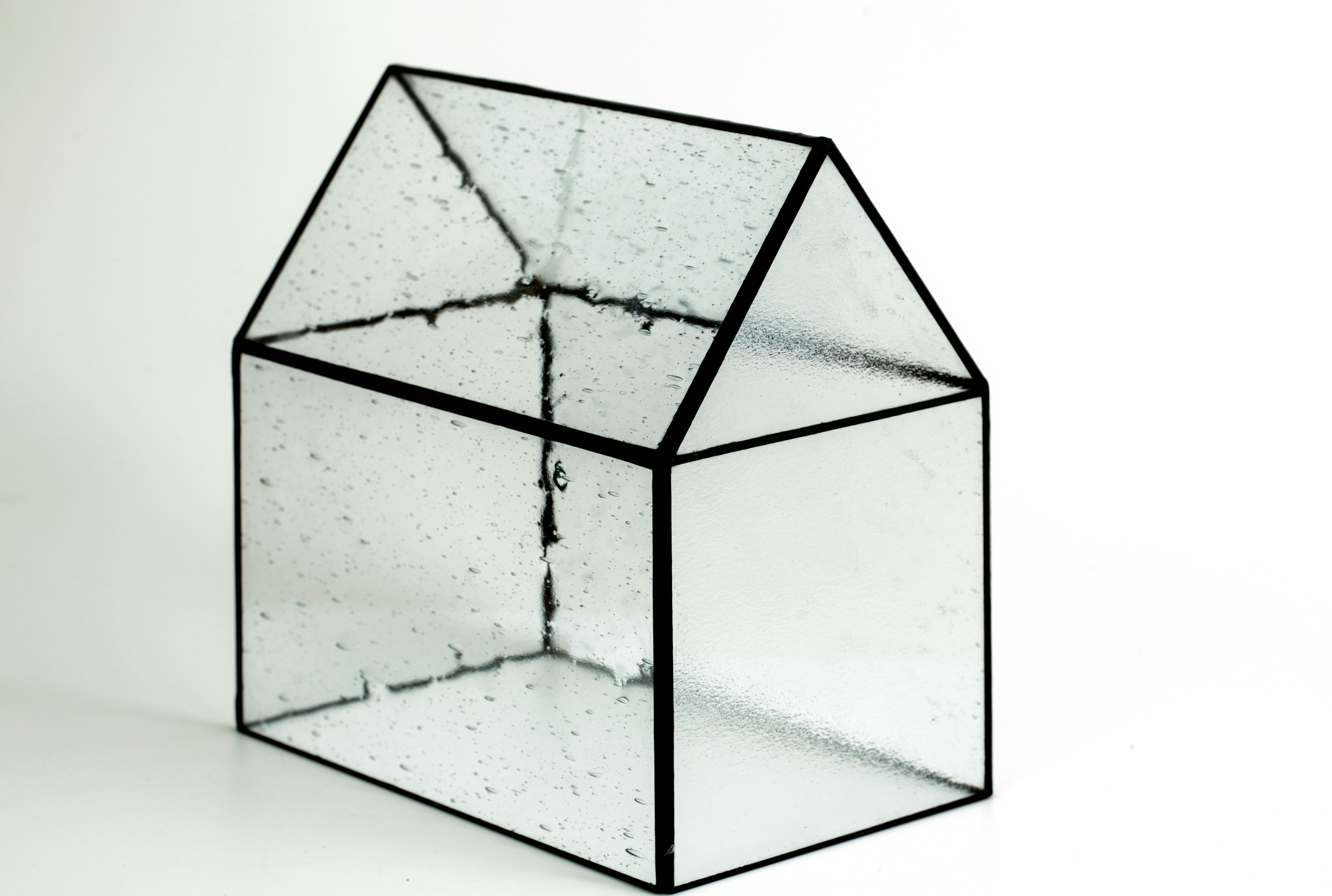 Fotografia de uma caixa transparente em formato de casa.